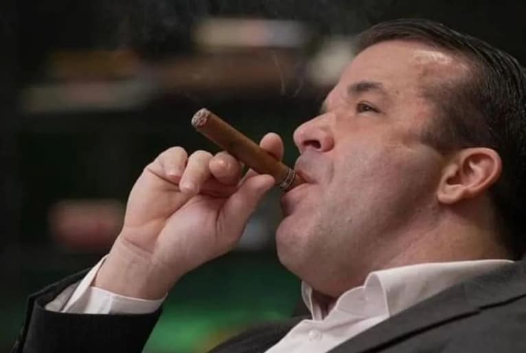 Thiago Brennand Vieira segura um charuto com a mão enquanto traga